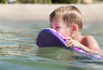 Image showing Little boy swimming on board near the beach