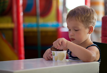 Image showing Little child eating chocolate ice cream