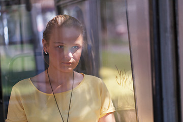 Image showing Young woman in yellow rides the bus