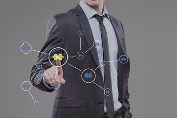 Image showing Close up of businessman hand touching abstract puzzle piece. technology and internet concept.