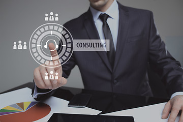 Image showing Businessman pressing button on touch screen interface and select Consulting. Business, internet, technology concept.