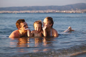 Image showing Laughing little boy with his parents at the sea