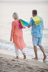 Image showing Couple walking on the beach after vacation shopping