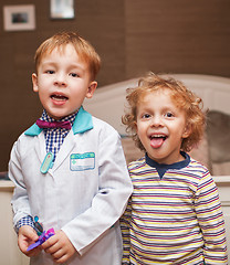 Image showing Little doctor and his patient showing tongue