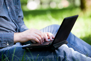 Image showing Detail of hands and laptop keyboard.