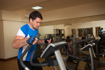 Image showing Man exercising on elliptical machine in gym