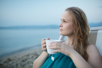 Image showing Woman enjoying a cup of tea at the seaside