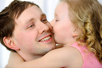 Image showing Little girl kissing fathers cheek