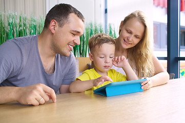 Image showing Happy family of three with tablet computer in cafe