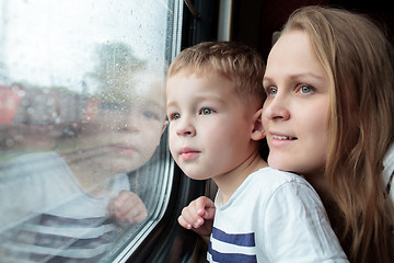 Image showing Mother and son looking through a train window