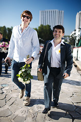 Image showing Two smiling men walking down a street