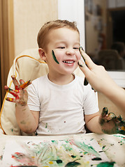 Image showing Happy little boy doing finger painting