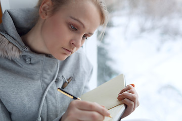Image showing Young girl writing in her journal.