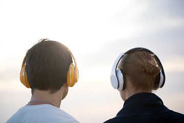 Image showing Young people in headphones enjoying music outdoor