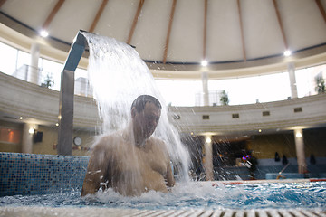 Image showing Man under water stream in the swimming pool