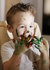 Image showing Excited little boy playing with finger paints