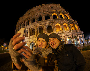 Image showing Happy couple making selfie by Coliseum at night