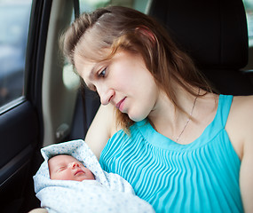 Image showing Woman holding newborn baby sitting in the car