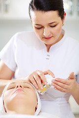 Image showing Cosmetician is going to apply facial cosmetic