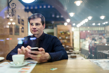 Image showing Man at the table texting