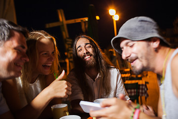 Image showing Happy friends watching photos on the cell