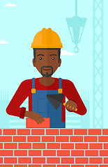 Image showing Bricklayer with spatula and brick.