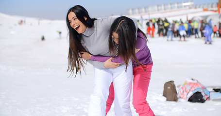 Image showing Two playful woman frolicking in the snow