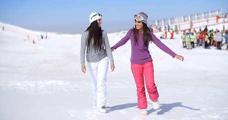 Image showing Two attractive young woman walking in fresh snow