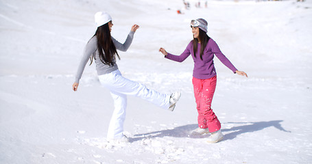 Image showing Two young woman frolicking in winter snow