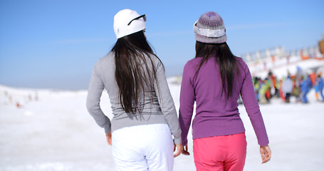 Image showing Two young woman walking in a winter ski resort