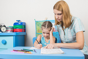 Image showing  Tutor teaches the child to write letters