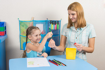 Image showing Five-year girl takes pencil from mother hands