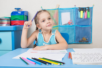 Image showing Five-year girl scratched his head and wondered pencil drawing picture at table