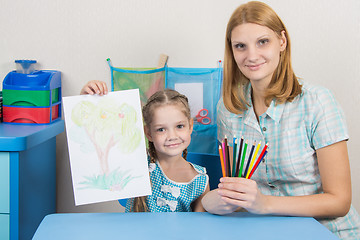 Image showing Five-year girl shows a drawing which she painted with her mother