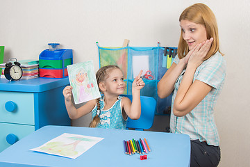 Image showing Five-year girl painted a mother and shows her mother surprised and happy