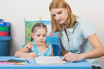 Image showing Mentor shows five children to write letters correctly