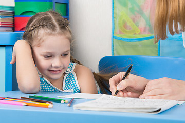 Image showing Five-year girl with a smile looking at my mother explaining how to write letters