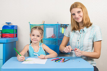 Image showing The five-year child draws on a sheet of paper, pencils undermines mom