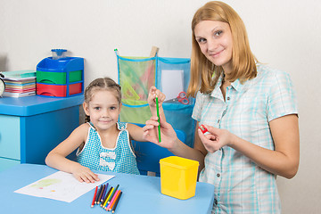 Image showing The five-year child put a finger on the tip of a pencil mother, and together looked in the frame