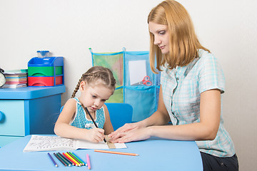 Image showing Young girl helps a five-year girl draw a straight line with a ruler