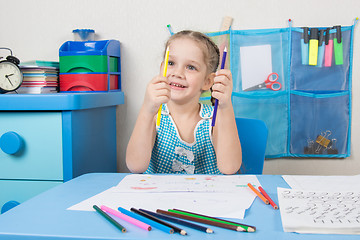 Image showing Happy five year old girl chooses the correct pencil drawing at the table