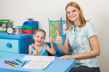 Image showing Mentor and five-year girl joyfully show the thumbs up by doing a regular job