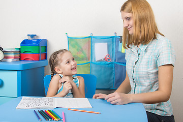 Image showing The girl is happy and looks at the teacher in kindergarten