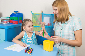 Image showing The five-year child put a finger on the tip of a pencil mom