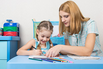 Image showing Girl and mother fun in a notebook draw