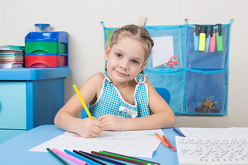 Image showing Happy five year old girl draws pencil and looked into the frame