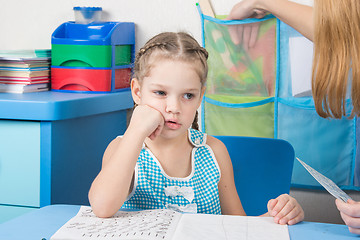 Image showing Five-year girl thought doing spelling under the supervision of a tutor