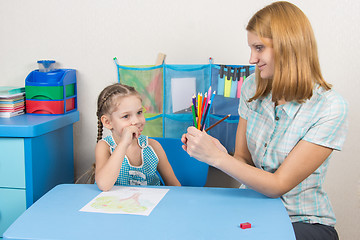 Image showing Five-year girl choose the right pencil from the teacher hands