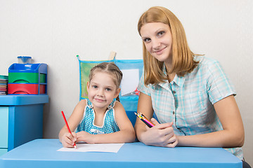 Image showing Mentor and five year old child draw with pencils sitting at the table