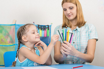 Image showing The five-year child picks a pencil in the hands of mother